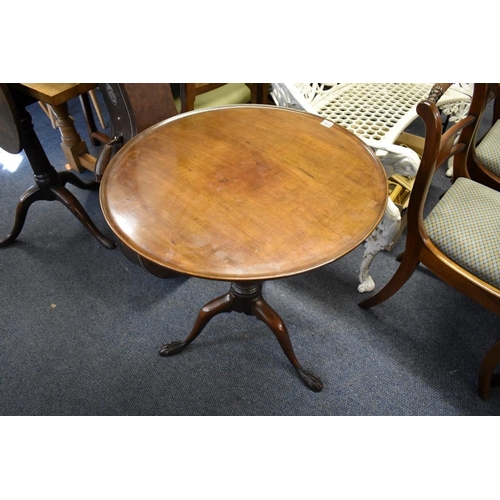 1922 - A George III mahogany circular tripod table, the dished one piece top revolving on a birdcage action... 