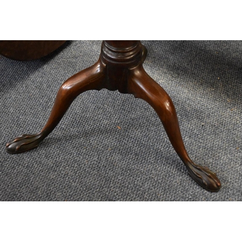 1922 - A George III mahogany circular tripod table, the dished one piece top revolving on a birdcage action... 