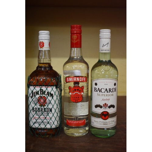 83 - Three bottles of spirits, comprising: a 1 litre Jim Beam Bourbon; a 70l Smirnoff vodka; and a 70cl B... 