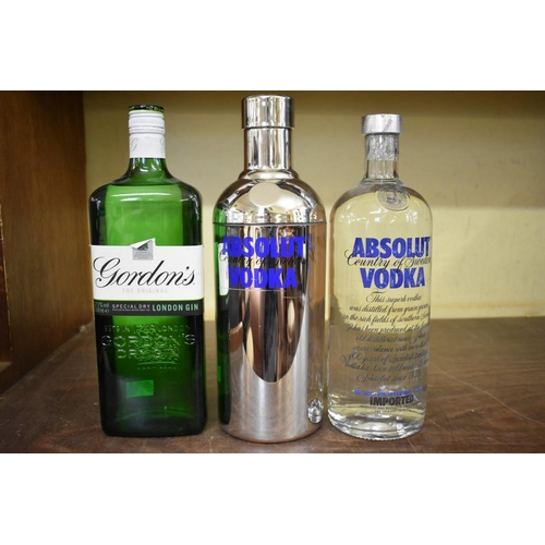 86 - Two 1 litre bottles of Absolut vodka, one in tube; together with a 1 litre bottle of Gordon's gin. (... 