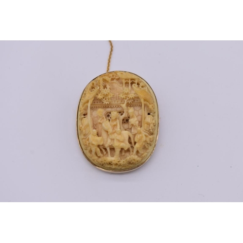 651 - A Chinese carved ivory and 9ct gold mounted oval brooch, the whole 4.7 x 3.7cm.