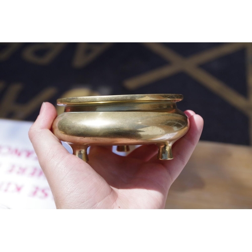 625 - A Chinese polished bronze tripod censer, xuande six character mark to base, 11.5cm diameter, 367g.... 