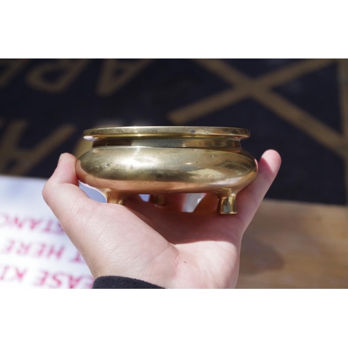 625 - A Chinese polished bronze tripod censer, xuande six character mark to base, 11.5cm diameter, 367g.... 