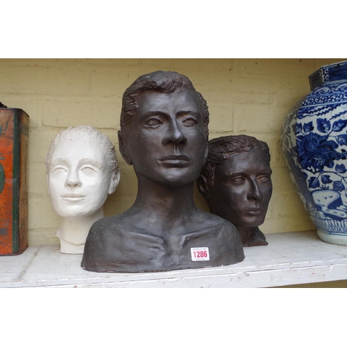 1286 - A concrete head and shoulder bust of man, unsigned, 34cm; together with two similar pottery heads.... 