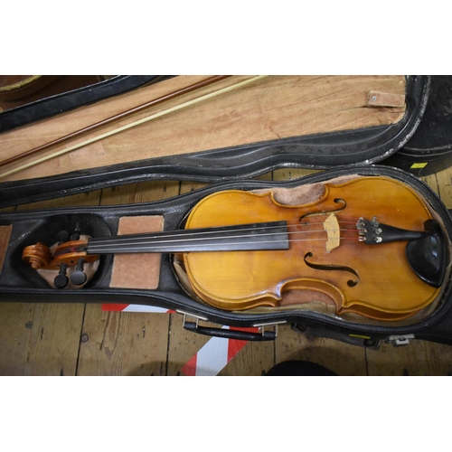 1754 - An old violin, stamped 'Paganini', having 12½in back, with bow, cased; together with two other cased... 