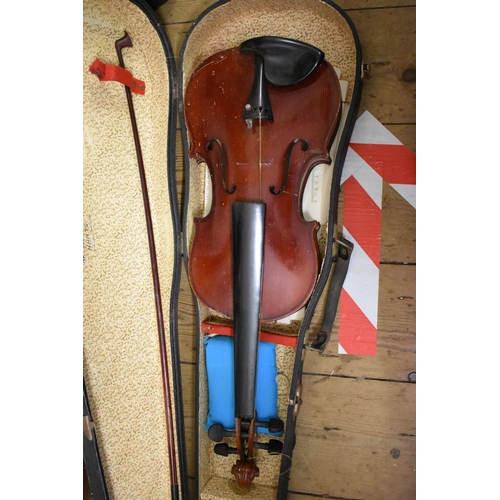 1754 - An old violin, stamped 'Paganini', having 12½in back, with bow, cased; together with two other cased... 