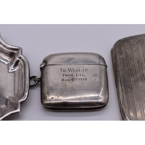 103 - A small group of silver and other metal items, comprising: a silver cigarette case, a silver vesta c... 