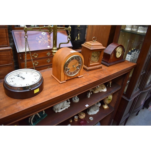 1349 - A collection of four various clocks and timepieces, to include a 1930s walnut dome top example ... 