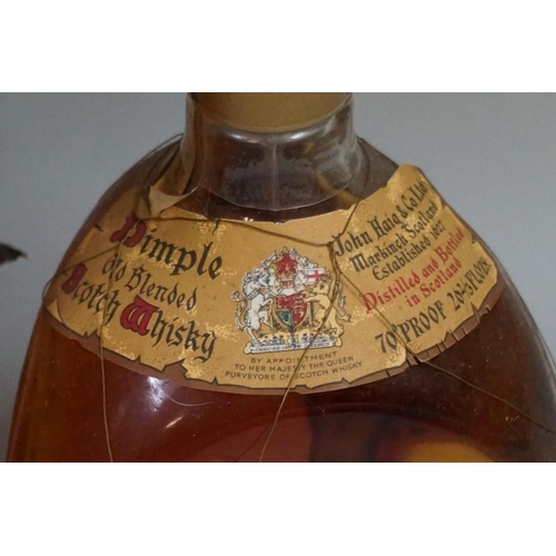 694 - Two old 26 2/3 fl.oz. bottles of Dimple blended whisky, comprising: a 1950s bottling, with spri... 