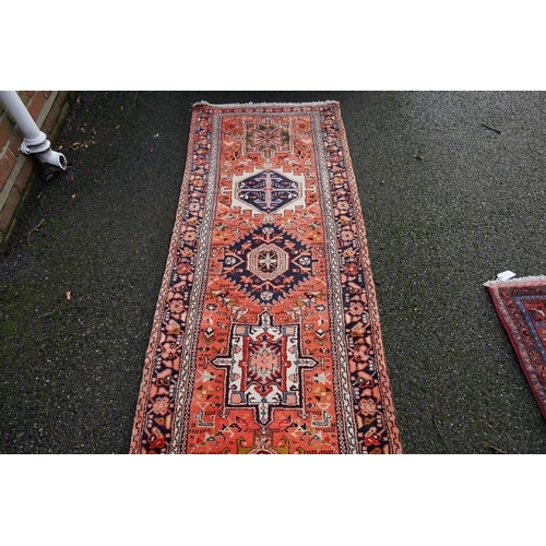 1066 - A large Persian runner, having fifteen central medallions, central field decorated with birds and fl... 