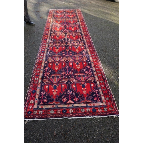 1071 - A large Persian runner, on a red and blue ground, having floral borders, 390 x 122cm.... 