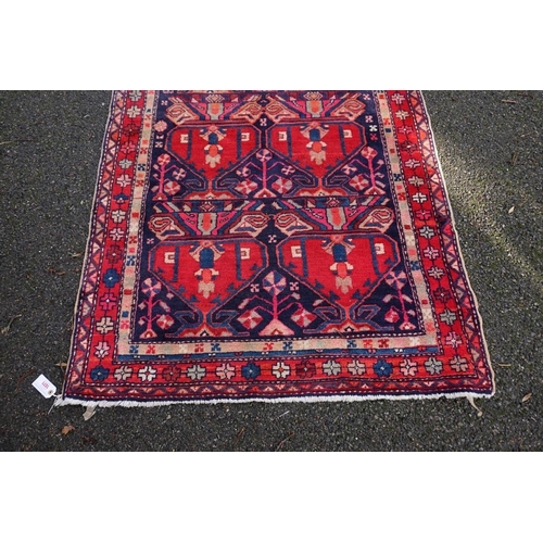 1071 - A large Persian runner, on a red and blue ground, having floral borders, 390 x 122cm.... 