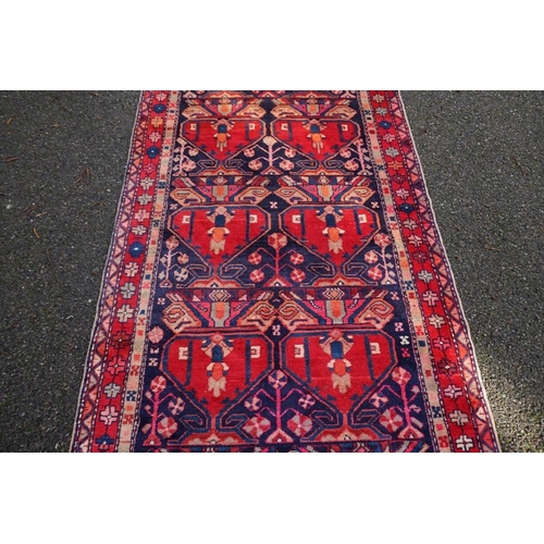 1071 - A large Persian runner, on a red and blue ground, having floral borders, 390 x 122cm.... 