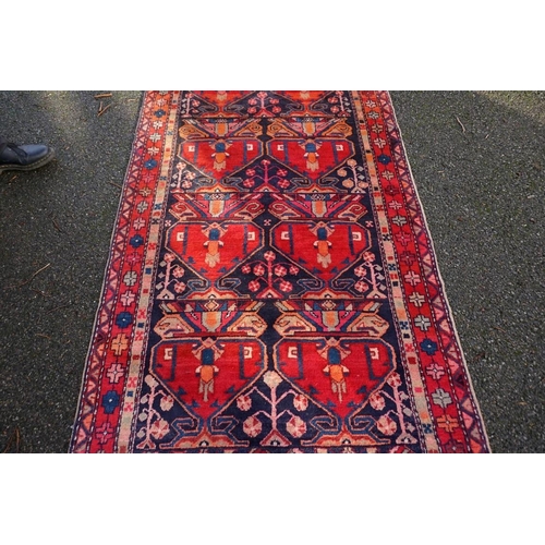 1071 - A large Persian runner, on a red and blue ground, having floral borders, 390 x 122cm.... 