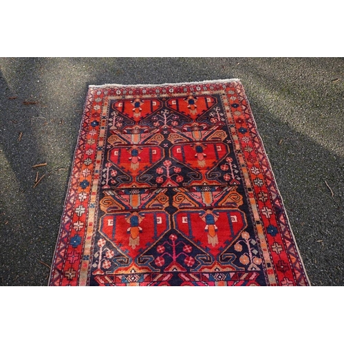 1071 - A large Persian runner, on a red and blue ground, having floral borders, 390 x 122cm.... 