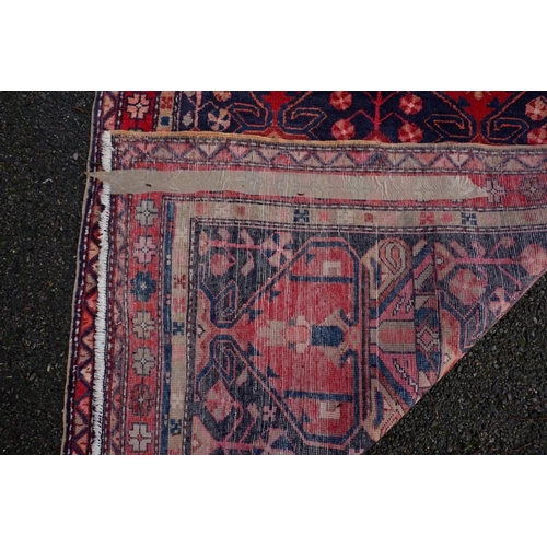 1071 - A large Persian runner, on a red and blue ground, having floral borders, 390 x 122cm.... 