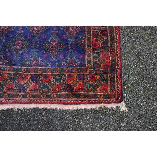 1075 - A Persian rug, having repeated design to central field, with geometric and floral borders, 242 x 120... 