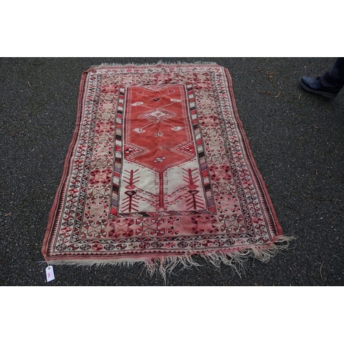 1083 - A Persian rug, central field decorated with figures with geometric borders, 169 x 126cm.... 