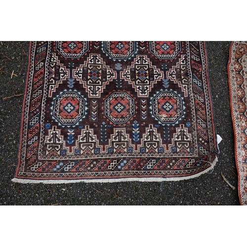 1086 - A Persian rug, having repeated design to central field with geometric borders on a red ground, 202 x... 