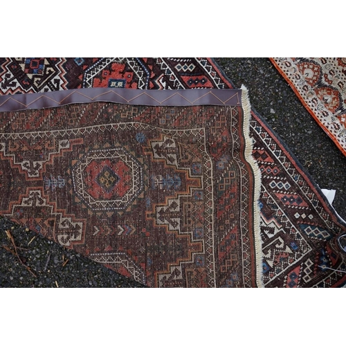 1086 - A Persian rug, having repeated design to central field with geometric borders on a red ground, 202 x... 