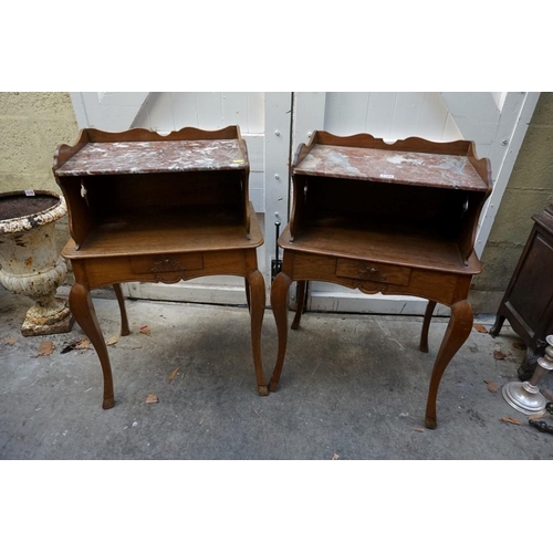 1184 - A pair of Continental oak and marble top bedside tables, 53.5cm wide.