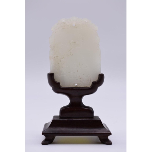 1251 - A Chinese carved pale celadon jade pendant, probably Qing, decorated in shallow relief with flowerin... 