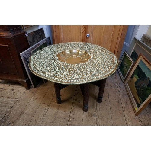 1303 - An Eastern brass top folding occasional table, 79cm diameter. 