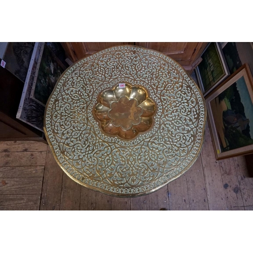 1303 - An Eastern brass top folding occasional table, 79cm diameter. 