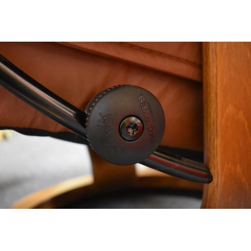 1460 - An Ekornes 'Stressless' brown leather chair and matching footstool.