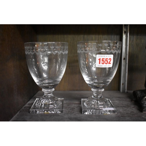 1552 - A pair of clear glass pedestal rummers, with engraved decoration to the rim, 13.5cm high.... 