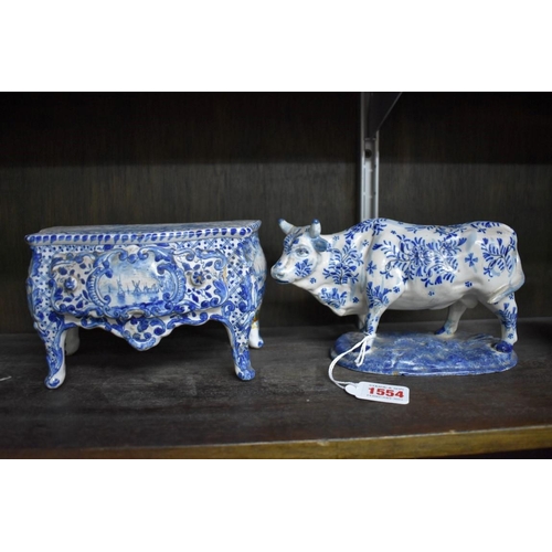 1554 - A Delft miniature commode, 18cm wide; together with another similar cow, 20cm long, (both s.d.).... 