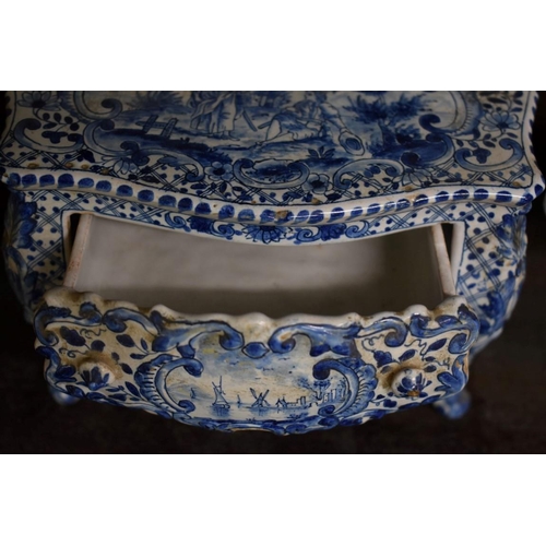 1554 - A Delft miniature commode, 18cm wide; together with another similar cow, 20cm long, (both s.d.).... 