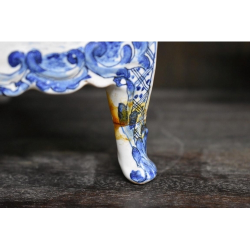 1554 - A Delft miniature commode, 18cm wide; together with another similar cow, 20cm long, (both s.d.).... 