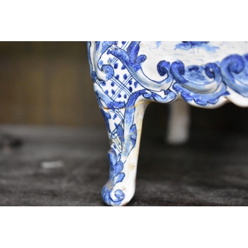 1554 - A Delft miniature commode, 18cm wide; together with another similar cow, 20cm long, (both s.d.).... 