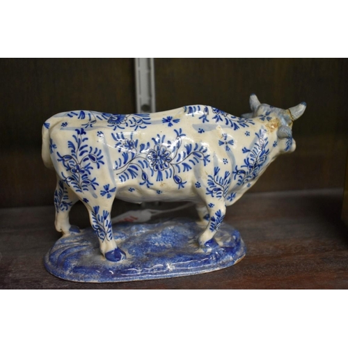 1554 - A Delft miniature commode, 18cm wide; together with another similar cow, 20cm long, (both s.d.).... 