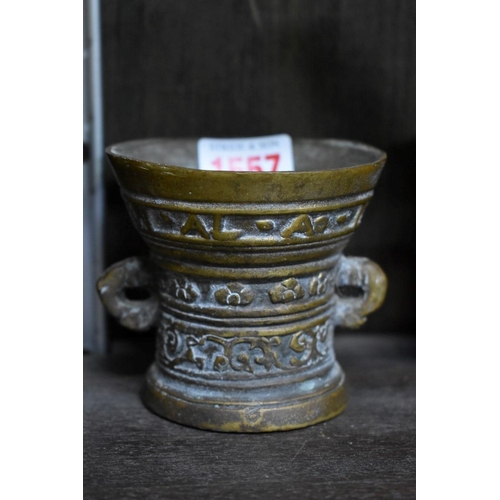 1557 - A brass or bronze twin handled mortar, 7.5cm high; together with two further mortars and pestles; an... 