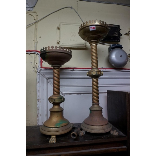 1598 - A graduated pair of brass ecclesiastical candlesticks, largest 62cm high.