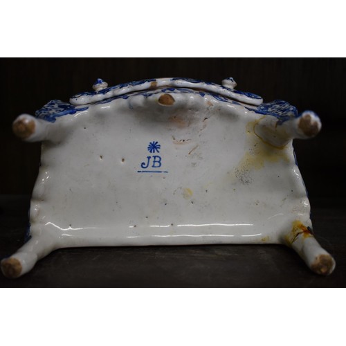 1554 - A Delft miniature commode, 18cm wide; together with another similar cow, 20cm long, (both s.d.).... 