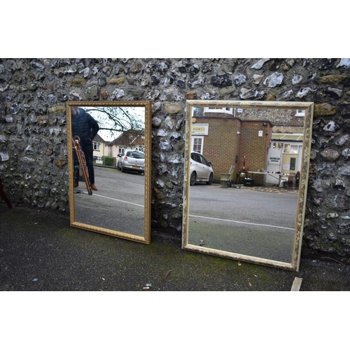 1058 - A gilt wall mirror, 110cm high x 84cm wide; together with another wall mirror, 112cm high x 85cm wid... 