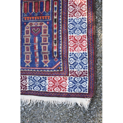 1094 - A Persian rug, having temple and urn design to central field, on a red and blue ground, 128 x 85cm.... 