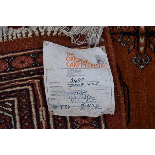 1094a - A Bokhara carpet, having repeated design to central field on an orange ground, 343cm x 247cm. ... 