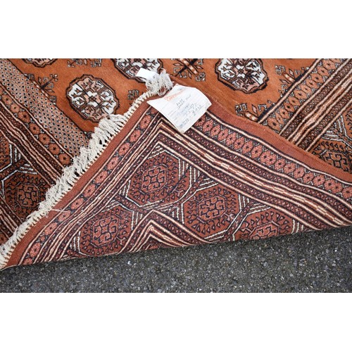 1094a - A Bokhara carpet, having repeated design to central field on an orange ground, 343cm x 247cm. ... 