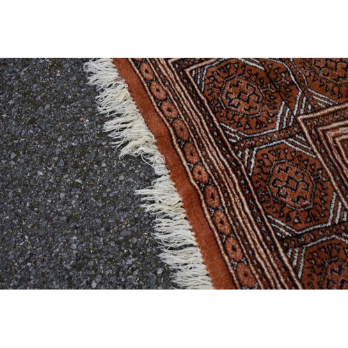 1094a - A Bokhara carpet, having repeated design to central field on an orange ground, 343cm x 247cm. ... 