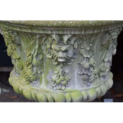 1068 - A concrete garden urn decorated with lion heads, 52.5cm wide x 62cm high.Collection of this lot is s... 