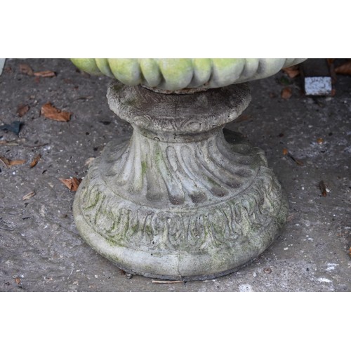 1068 - A concrete garden urn decorated with lion heads, 52.5cm wide x 62cm high.Collection of this lot is s... 