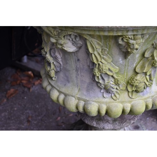 1068 - A concrete garden urn decorated with lion heads, 52.5cm wide x 62cm high.Collection of this lot is s... 