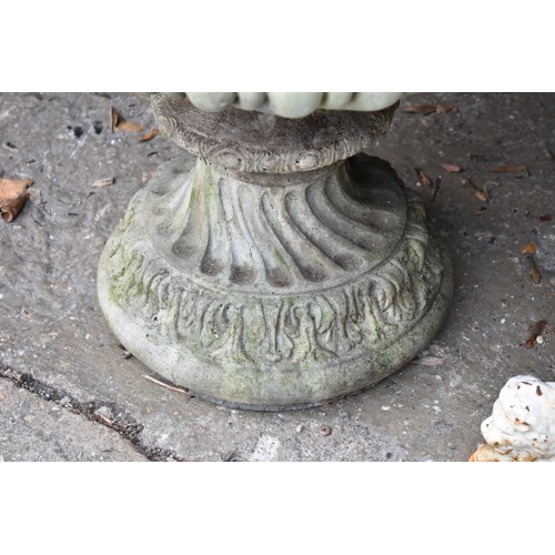 1068 - A concrete garden urn decorated with lion heads, 52.5cm wide x 62cm high.Collection of this lot is s... 