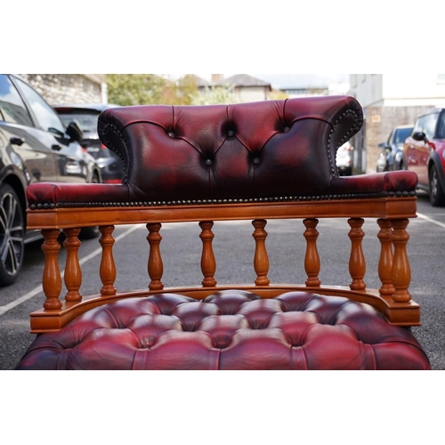 1048 - A reproduction red leather upholstered captains chair. 