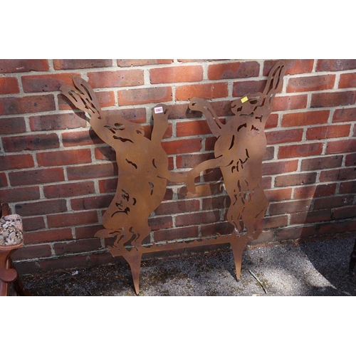 1067 - A steel garden ornament of fighting hares, 94cm high x 88cm wide.