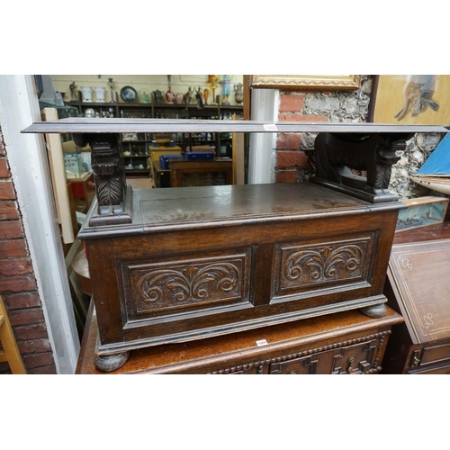 1088 - A carved oak monks bench, with hinged box seat, 106.5cm wide.